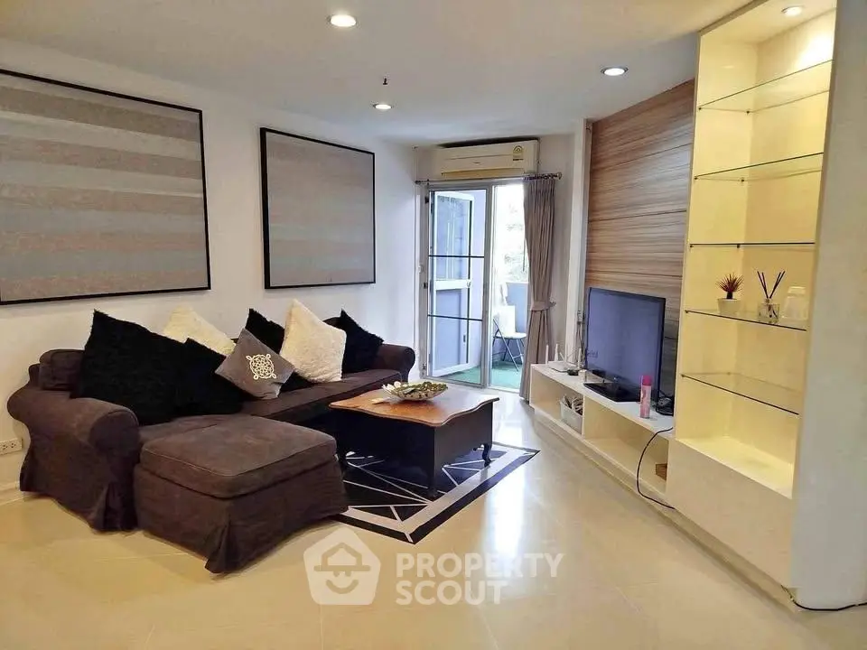 Stylish living room with modern decor and cozy seating in a bright apartment.