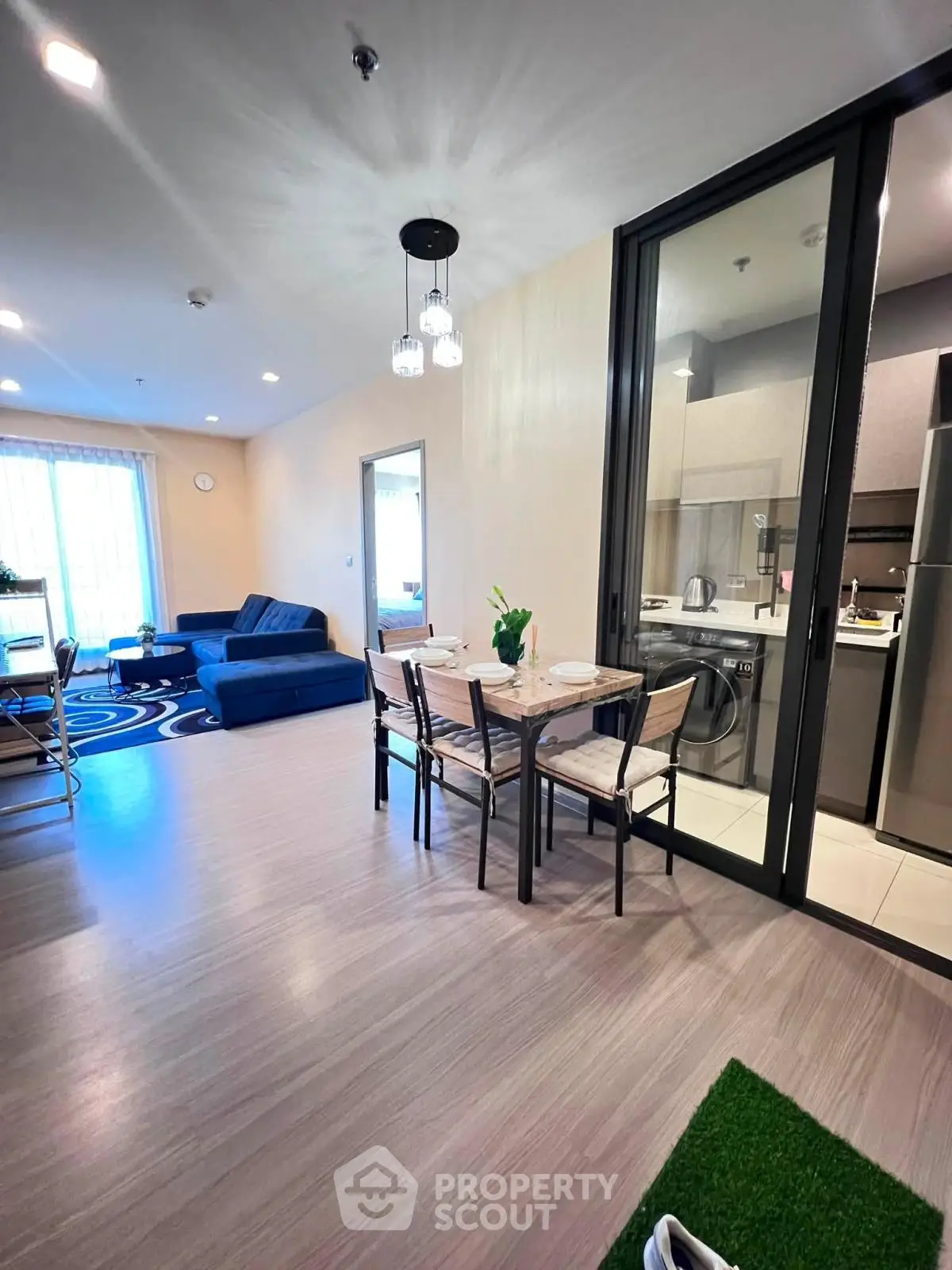 Modern open-plan living room with dining area and kitchen, featuring stylish decor and ample natural light.