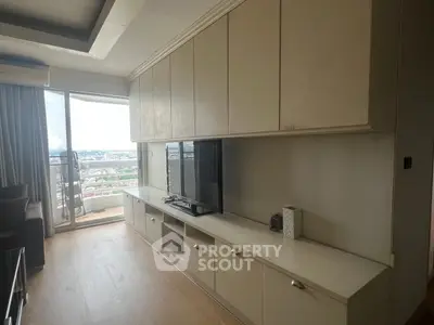 Spacious living room with built-in cabinets and balcony view