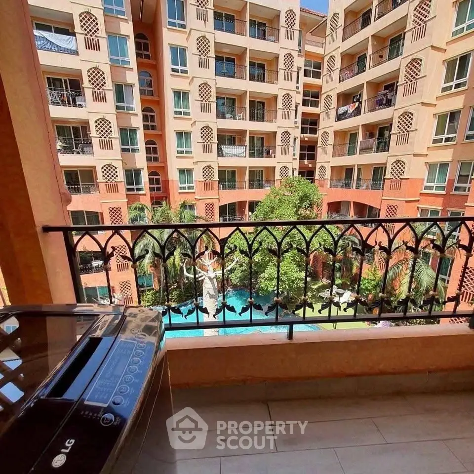 Spacious balcony with pool view in modern apartment complex