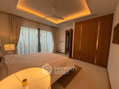 Luxurious bedroom with modern lighting and large window in upscale property