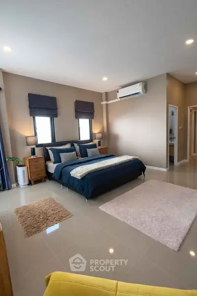 Spacious modern bedroom with stylish decor and natural light