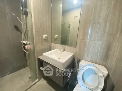 Modern bathroom with sleek design featuring a glass shower and contemporary fixtures.