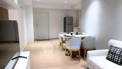 Modern living room with dining area and sleek kitchen appliances in a stylish apartment.