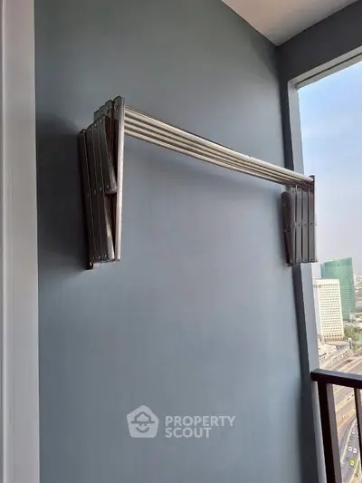 Modern balcony with retractable clothes drying rack and city view