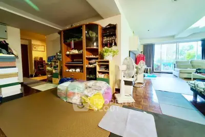 Spacious living room with large windows and cozy seating area, perfect for relaxation and entertaining.