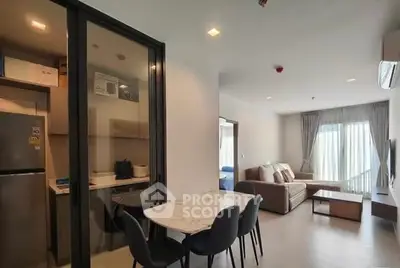 Modern open-plan living room with dining area and kitchen in a stylish apartment.