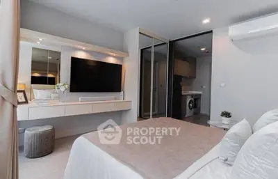 Modern bedroom with sleek design, featuring a large TV and mirrored wardrobe.