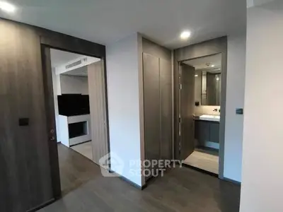 Modern apartment hallway with sleek wooden doors and ambient lighting.