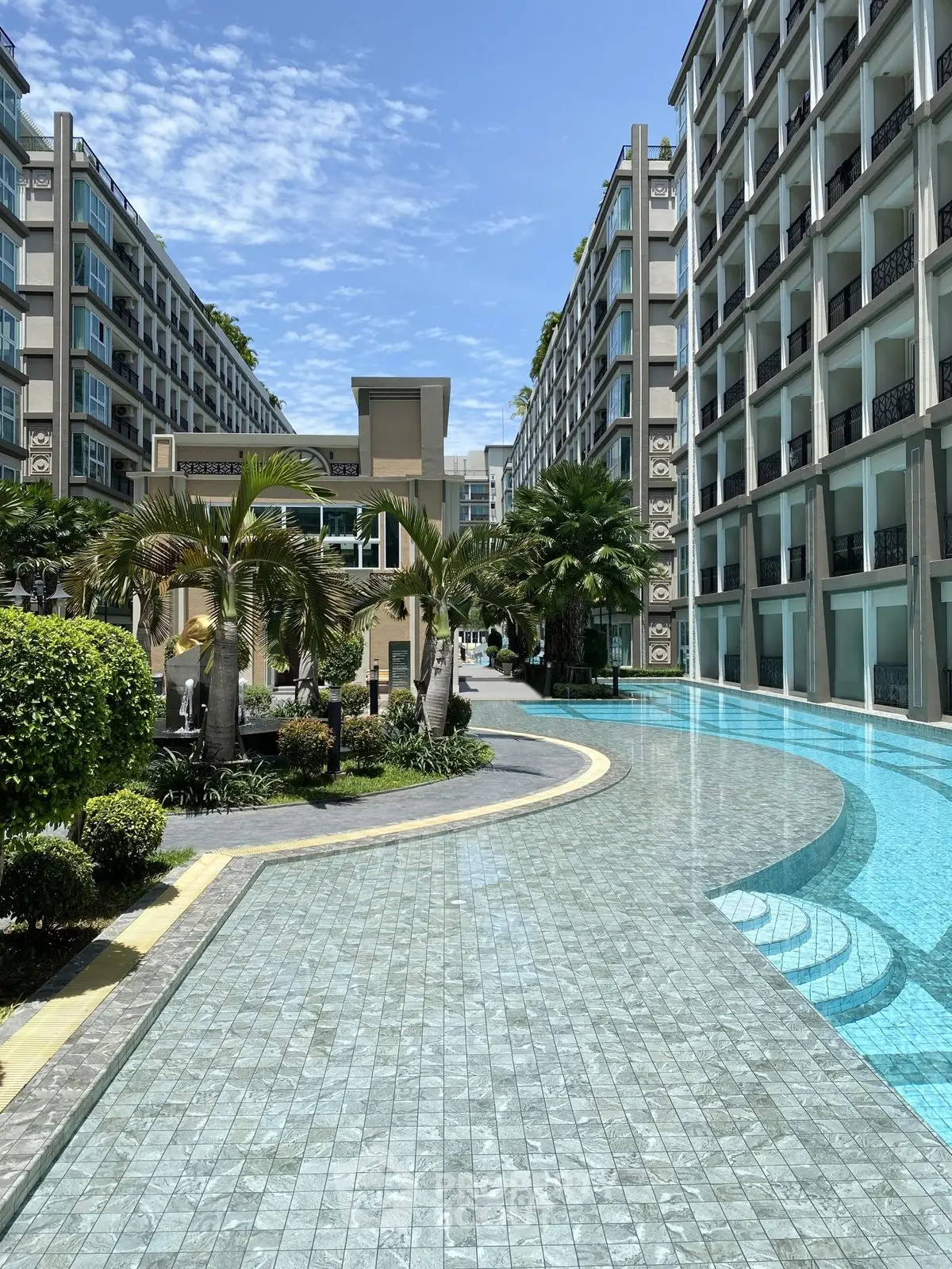 Luxurious apartment complex with stunning pool and lush greenery