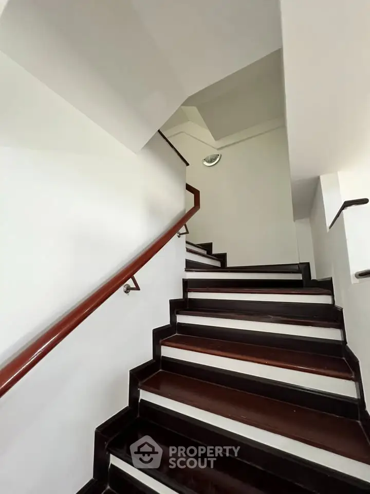 Elegant staircase with dark wood accents in modern building interior