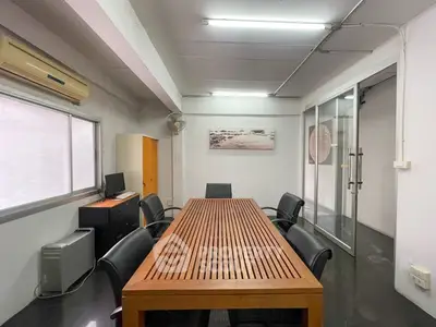 Modern office space with sleek conference table and glass door entry