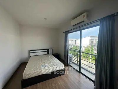 Spacious bedroom with large window and balcony access in modern apartment.
