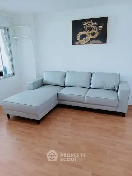 Modern living room with sleek gray sectional sofa and wooden flooring