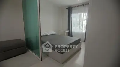 Modern bedroom with minimalist design and large window for natural light.