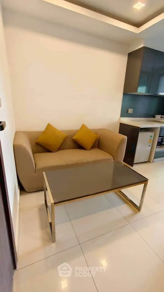 Modern living room with cozy sofa and sleek kitchen area, perfect for urban living.