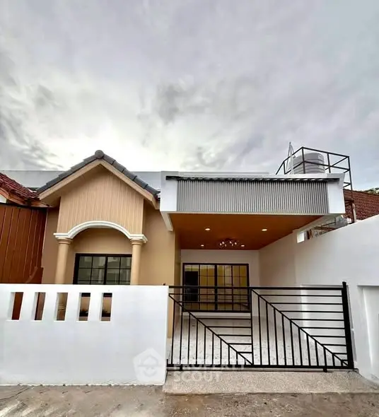 Charming single-story home with modern facade and gated entrance, perfect for family living.