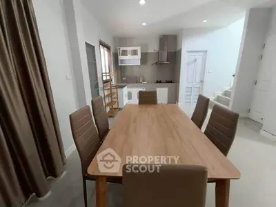 Modern dining area with sleek kitchen and wooden table in open layout