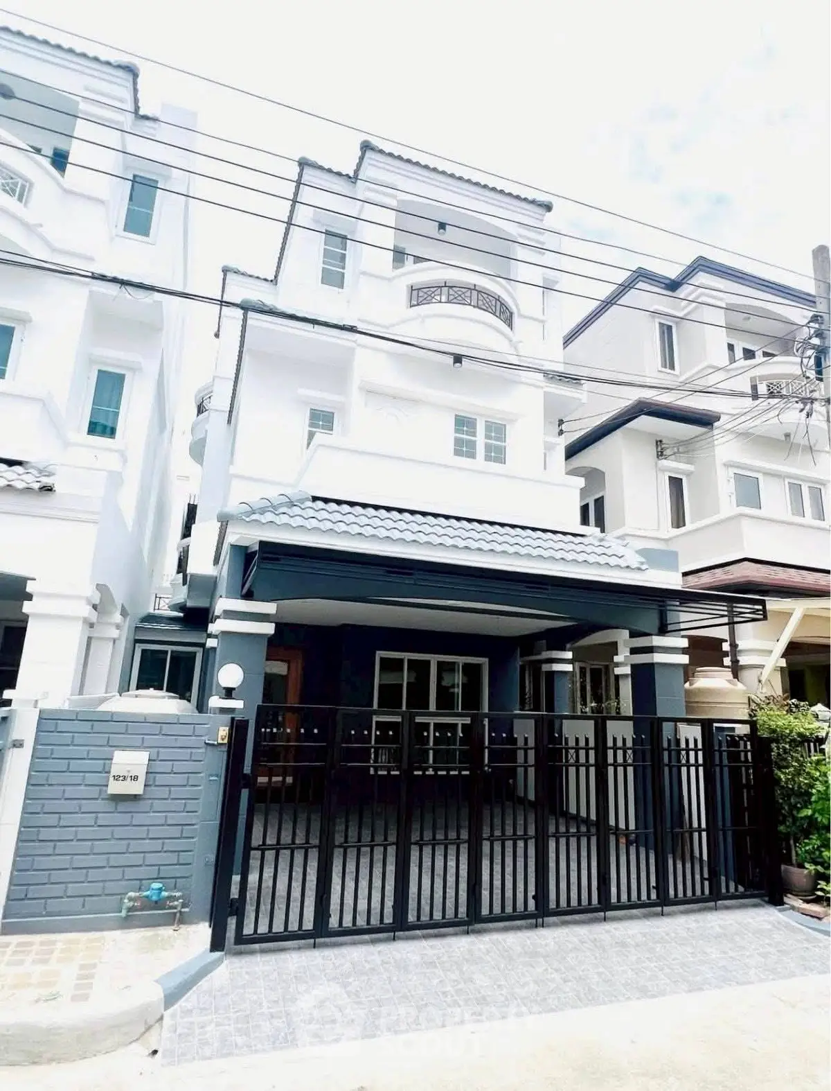 Modern three-story townhouse with gated entrance and stylish facade