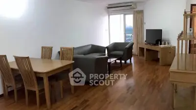 Spacious living room with modern furniture and wooden flooring, perfect for family gatherings.