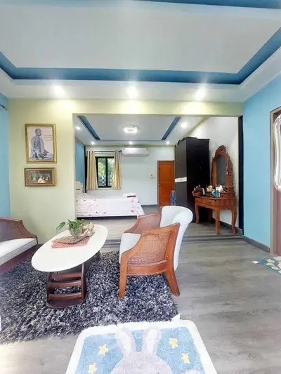 Spacious living room with modern decor and cozy seating area, leading to a stylish bedroom.