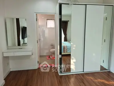 Modern bedroom with sleek wardrobe and wooden flooring