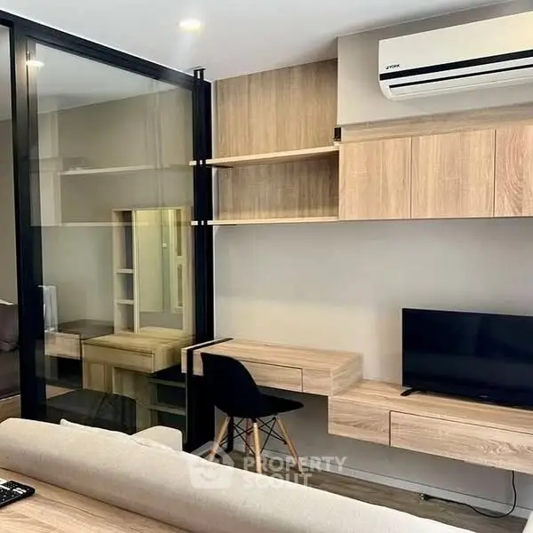 Modern living room with sleek furniture and wall-mounted TV, featuring a stylish air conditioning unit.