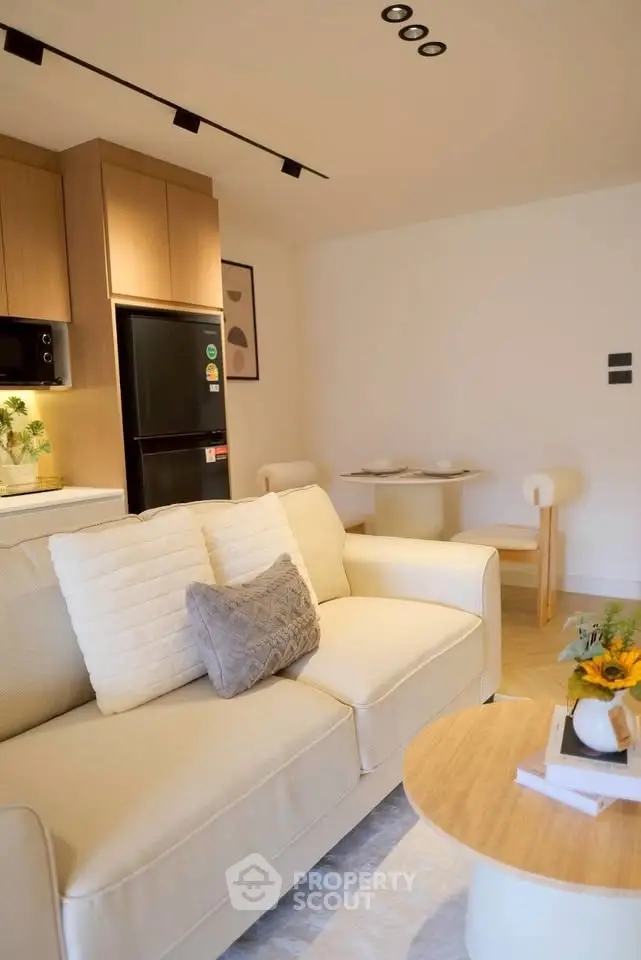 Modern living room with cozy sofa, stylish kitchen, and elegant dining area in open layout apartment.