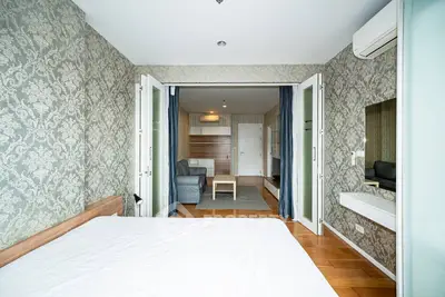 Spacious bedroom with elegant wallpaper and open layout to living area