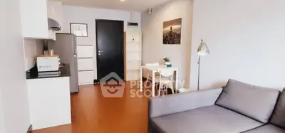 Modern open-plan living room with kitchen and dining area, featuring sleek furniture and contemporary decor.