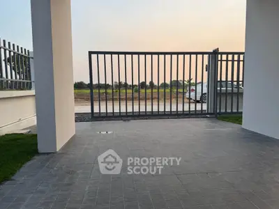 Modern gated entrance with sleek design and spacious driveway