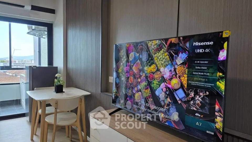 Modern living room with sleek TV and dining area, featuring a balcony with city views.