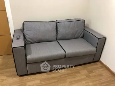 Modern gray sofa in a cozy living room with wooden flooring