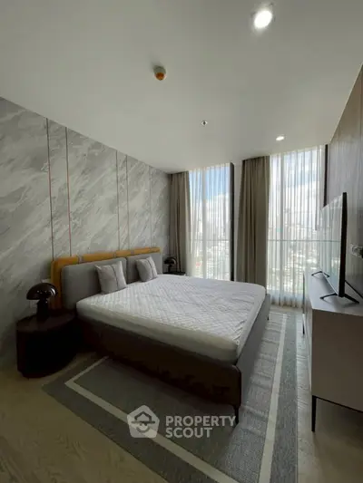 Modern bedroom with large windows and stylish decor in a high-rise apartment.