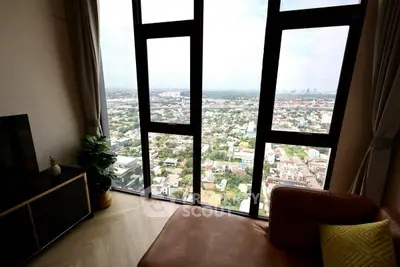 Stunning high-rise living room with panoramic city view through floor-to-ceiling windows.