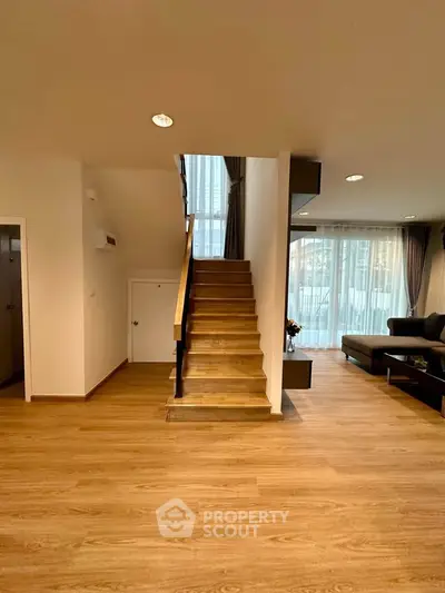 Spacious modern living room with wooden staircase and large windows
