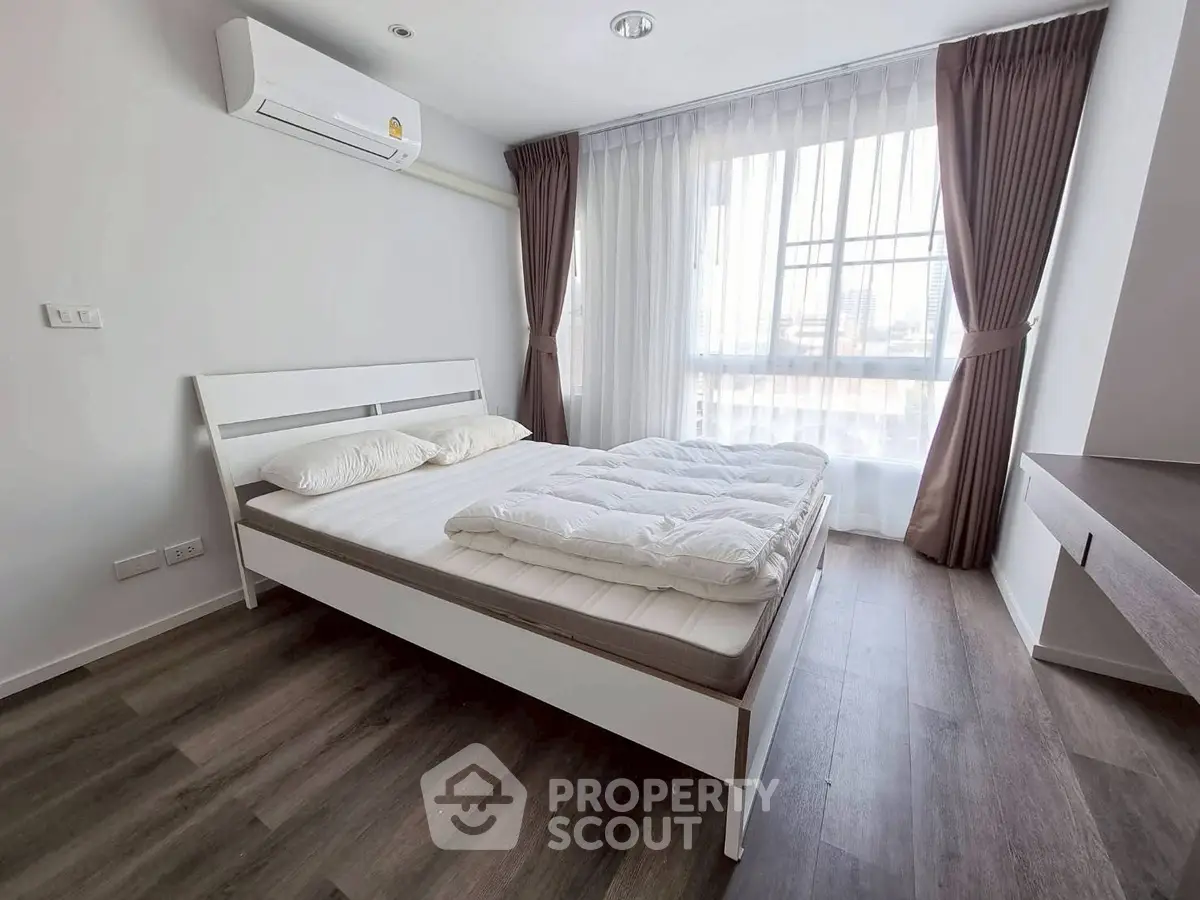 Modern bedroom with large window and stylish decor in a bright apartment