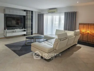Spacious modern living room with elegant white sectional sofa and large TV unit.