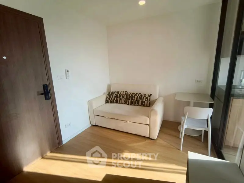 Cozy living room with natural light, featuring a comfortable sofa and modern decor.