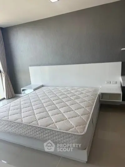 Spacious modern bedroom with large window and stylish decor