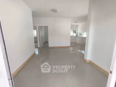 Spacious modern living room with glossy tiled floors and large windows for natural light.