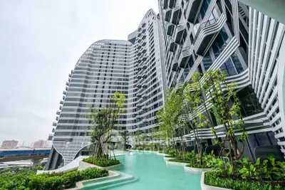 Stunning modern high-rise building with lush greenery and pool, offering luxurious urban living.