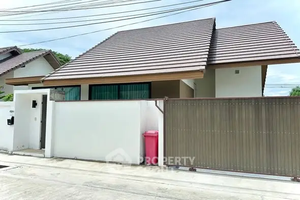 Charming single-story home with modern roof and gated entrance in a serene neighborhood.