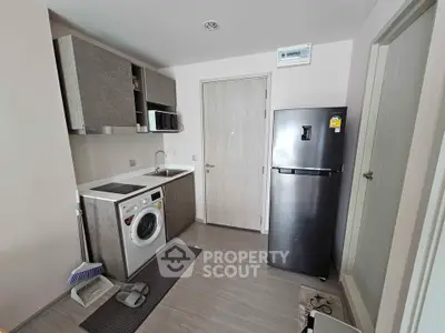 Modern kitchen with washing machine and fridge in compact layout