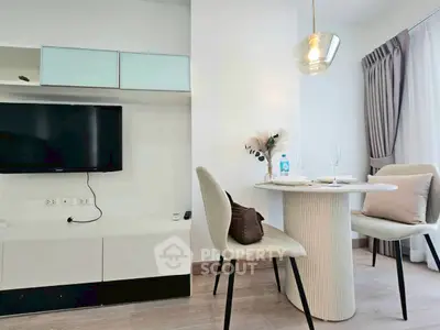 Modern living room with stylish dining area and wall-mounted TV in a bright apartment.