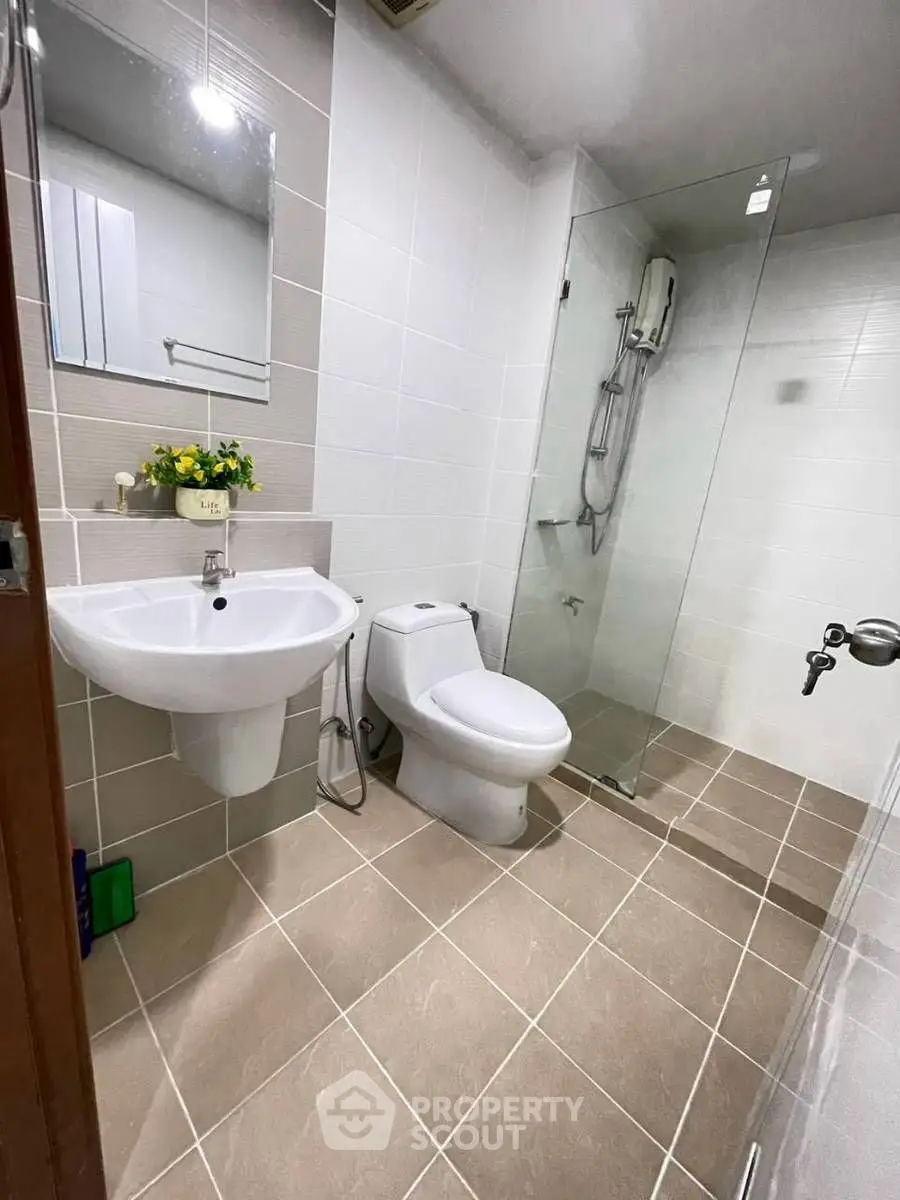 Modern bathroom with glass shower and sleek fixtures in a contemporary apartment.