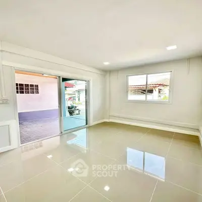 Bright and spacious room with glossy tiled floors and large windows.