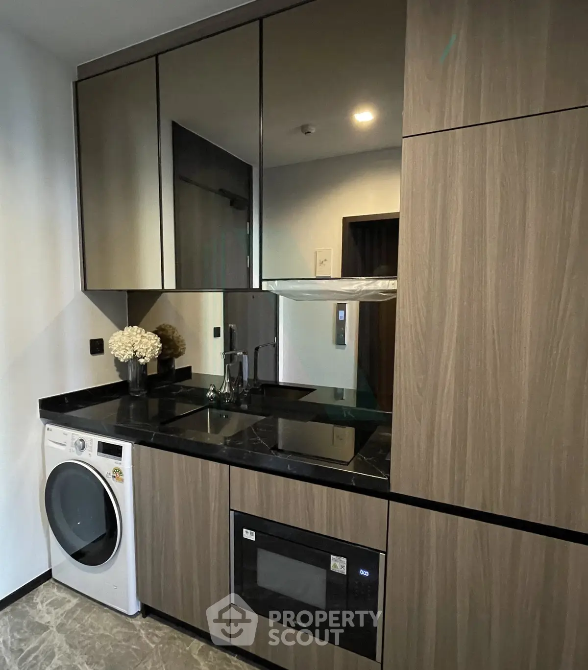 Modern kitchen with sleek cabinetry, built-in appliances, and stylish black countertop.