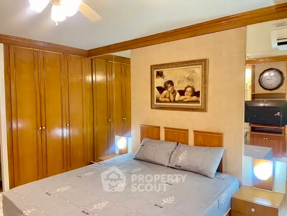 Cozy bedroom with wooden wardrobe and elegant decor, featuring a comfortable bed and classic artwork.