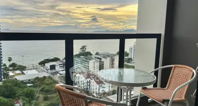Stunning ocean view from a modern balcony with cozy seating, perfect for relaxation and enjoying sunsets.